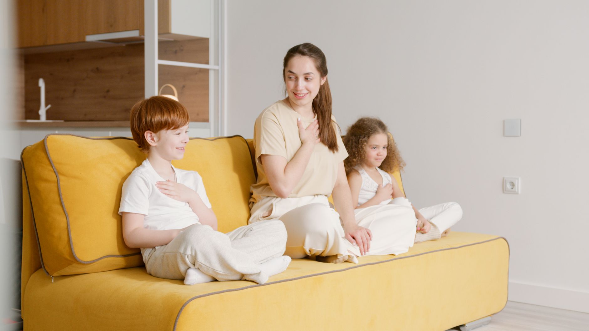 Mẹ hướng dẫn trẻ tập thở nhẹ trên ghế sofa